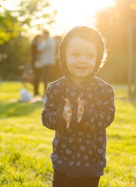 Niña pequeña juega en el parque en contraluz . —  Fotos de Stock