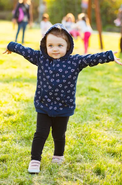 Kleines Mädchen spielt im Park im Gegenlicht. — Stockfoto