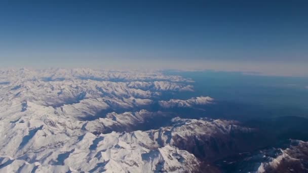 飛行機から雪が降ったアルプス ポートホールを通して地球 航空ビュー 飛行旅行の概念 — ストック動画