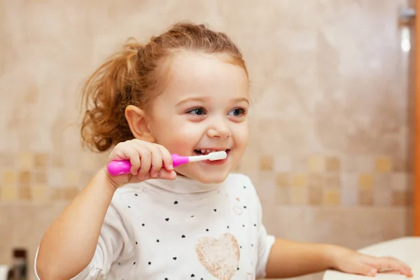 Niedliches kleines Mädchen putzt Zahn mit Bürste. — Stockfoto