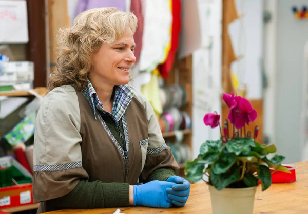 Florista com roupas profissionais em um berçário . — Fotografia de Stock