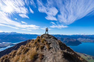 Genç Asyalı çift, Roy 's Peak Gölü Wanaka Yeni Zelanda' da el ele öpüşüyor.