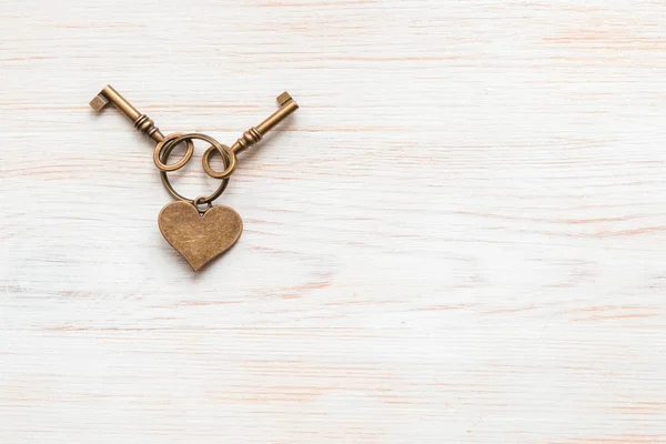 Brons kleurtoetsen en hart samen liggend op houten plank. Ruimte voor tekst. — Stockfoto