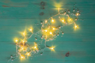 Christmas or New Year rustic green background with yellow lights of garland