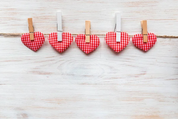 Red hearts row on clothespins at wooden border. Valentine's day background. Happy lover's day concept — Stock Photo, Image