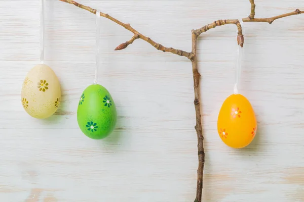 Branches de Pâques avec des œufs de Pâques suspendus sur fond de bois vintage peint en blanc — Photo
