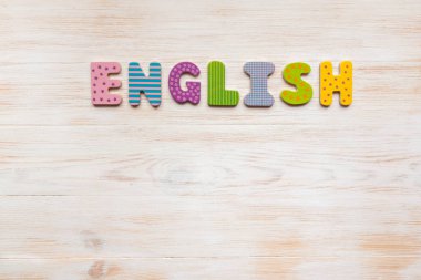 Tahta arka planda düzenlenmiş ahşap harflerden oluşan İngilizce kelime.