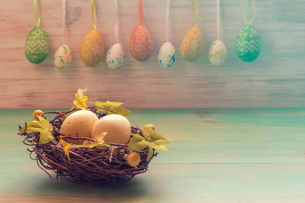 Concept de vacances de Pâques avec des jouets de lapins mignons et une rangée d'œufs de Pâques sur des lapins en bois vintage — Photo