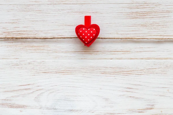 Одно красное сердце с горошек на прищепке на деревянной границе. День святого Валентина — стоковое фото
