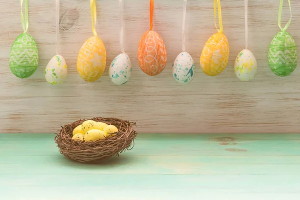 Concept de vacances de Pâques avec des brindilles nid avec des œufs et rangée d'œufs de Pâques sur des lapins en bois vintage — Photo