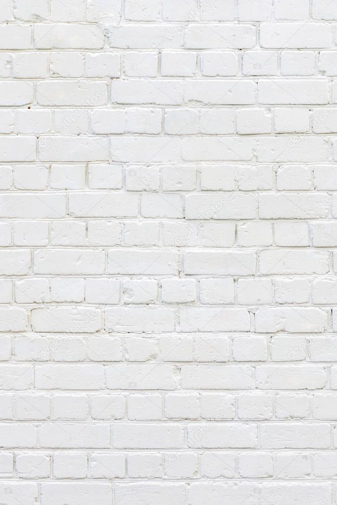 White painted brick wall. White background of bricks. Bricks whitewall. Abstract texture background. Vertical orientation.