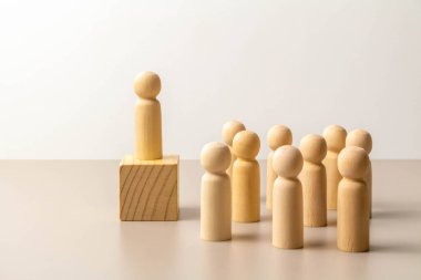 Tahta küpteki kalabalıktan öne çıkan lider figürü, yerdeki diğer figürler. Liderlik ve takım. Patron ve astları. Bireylik ve üstünlük.