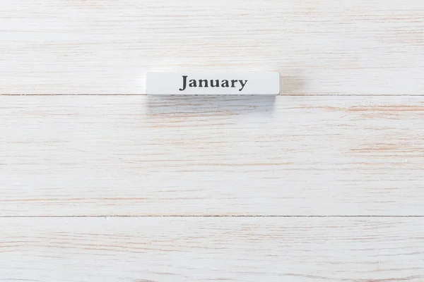 Whine wooden block of calendar with month January on vintage background. Inscription January on wood plank. Top view. Copy space. Mockup for calendar events. This is the one of 12-month series