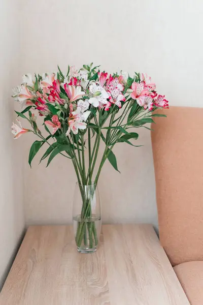 Cam vazodaki Alstroemeria Çiçekleri buketi masada. Alstroemeria çiçek arka planı. Çiçekler Alstroemeria. 
