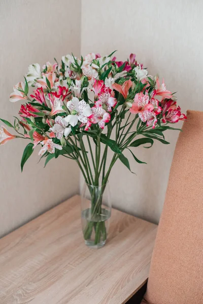 Cam vazodaki Alstroemeria Çiçekleri buketi masada. Alstroemeria çiçek arka planı. Çiçekler Alstroemeria. 