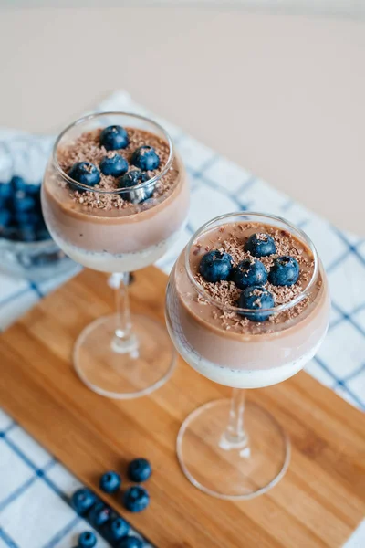 Lezzetli ve lezzetli İtalyan kremalı Panna Cotta sütlü ve çikolatalı chia tohumlarından yapılır. Taze yaban mersini ve çikolata kırıntılarıyla süslenmiş. Sağlıklı beslenme