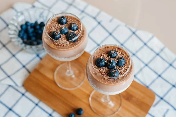 Lezzetli ve lezzetli İtalyan kremalı Panna Cotta sütlü ve çikolatalı chia tohumlarından yapılır. Taze yaban mersini ve çikolata kırıntılarıyla süslenmiş. Sağlıklı beslenme