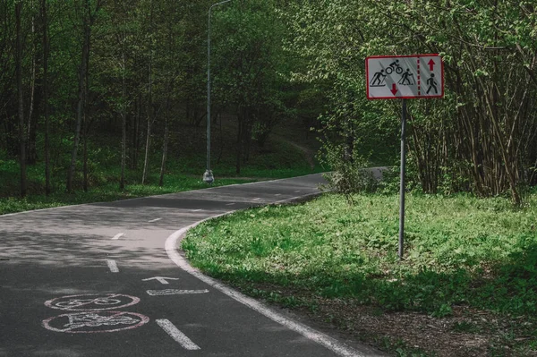 Ormanda yol işareti ve asfalt yol. 