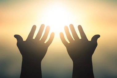 Uluslararası Yoga Günü kavramı: Gün batımında güneşi yakalayan yükseltilmiş eller