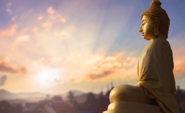 Vesak Günü kavramı: Buda heykeli doğada gün batımında bulanık arkaplan