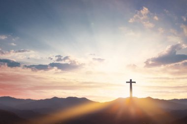 Good Friday concept: cross with sunset in the sky background