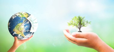 Dünya Çevre Günü kavramı: el ele tutuşma ağacı ve COVID-19 Dünya yeşil arka planda güneş ışığı maskesi takıyor, bu görüntü NASA tarafından destekleniyor.