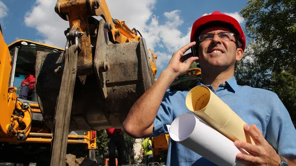 Arquiteto ou engenheiro com telefone celular no canteiro de obras — Fotografia de Stock