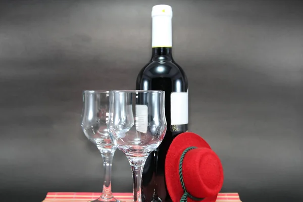 Botella de vino tinto con etiqueta vacía y dos copas aisladas sobre fondo negro — Foto de Stock