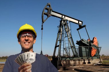  Yüksek ödeme işleri kavram / petrol işçi veya petrol mühendisi bize para petrol kuyusu önünde tutan. En iyi ücretli işler kavramı