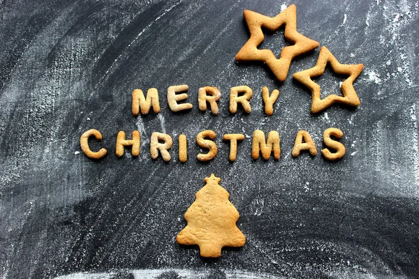 Pişmiş mektuplar Mutlu Noeller, yıldızlar, kar taneleri. Zencefilli tebrik kartı. Tahta masadaki zencefilli ekmekten yapılmış Noel kartı. Fırın tepsisindeki zencefilli kurabiyelerden mutlu noeller.