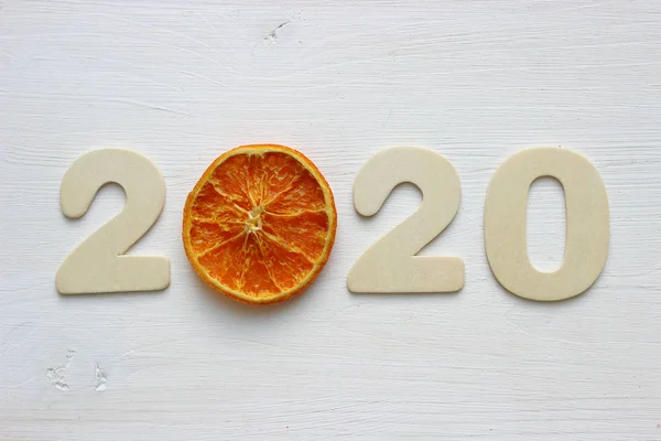 Beyaz ahşap arka planda ve kurutulmuş portakal dilimlerinde 2020 tane var. Uzayı kopyala Yeni yıl 2020 konsepti, Noel kartı.