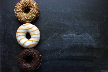 Beyaz arka planda çeşitli çörekler, üstte. Çikolata kremalı muhtelif donutlar. Boşluğun kopyası.