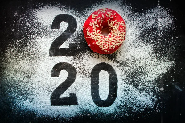 Metin 2020, siyah arka planda renkli çöreklerle çevrili, yeni yıl konsepti. Yeni yıl, Noel arkaplanı, fotokopi alanı, rakamlar 2020.