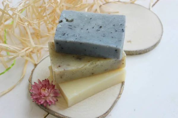 Handmade natural soap on wooden background. Spa natural treatments.Natural soap, handmade organic natural soap with body brush, oil bottle and cotton towel, spa and wellness products.