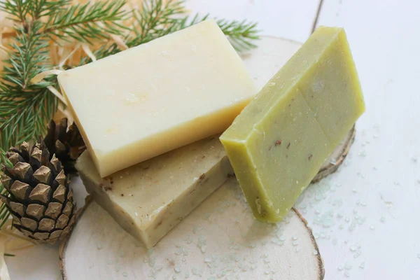 Ahşap arka planda doğal el yapımı sabun. Spa-doğal tedaviler. Çam aromalı doğal organik sabun, gerekli yağlar. Mevsimlik çam ağacı sabunu.