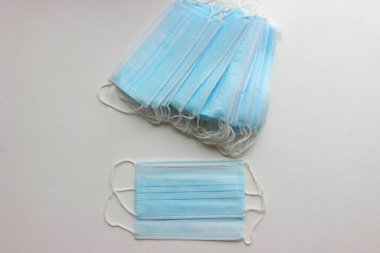 Beyaz arka planda tek kullanımlık tıbbi maskeler. Bulaşıcı hastalıklara karşı koruma. Kapatın. Cerrahi maske beyaz arka planda. Cerrahi koruyucu maske. Koronavirüs karantinası kavramı.