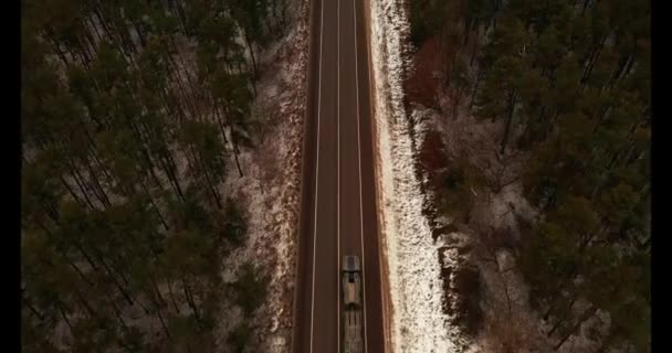 Вид зверху повітря. Рух по сільській дорозі причіп вантажівка і автомобіль на дорозі серед лісу . — стокове відео