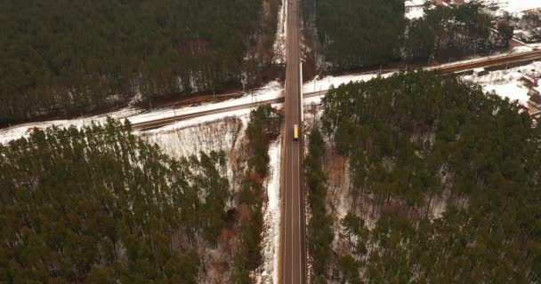 Aerial Top View. A truck with a trailer moves the bridge over the rails among the woods outside the city. — Stock Video