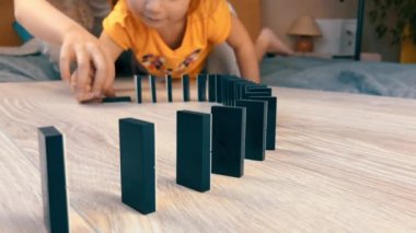 İki çocuğum var. Küçük kızlar evde domino taşlarıyla tek başlarına oynuyorlar. Yavaş çekim. 