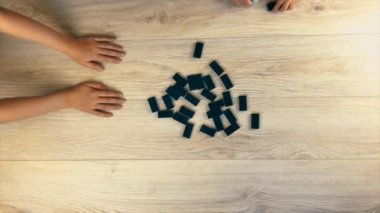Aile oyunu sırasında masada domino taşlarını karıştırmak. Yukarıdan görüntüle.