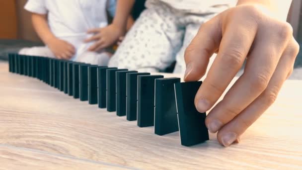 Kinder lassen Dominosteine in Zeitlupe auf den Tisch fallen — Stockvideo