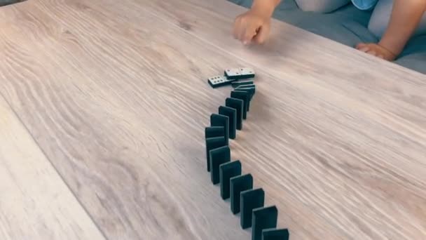 En vacker droppe dominobrickor på bordet. Dolly-skytte Långsam-mo. — Stockvideo