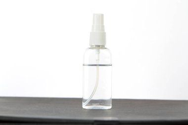 Şeffaf plastik şişe, üzerinde dezenfektan sıvısı olan beyaz arka planı olan koyu bir inleme. Plastik bir şişe sıvı ve şeker..