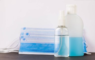 El hijyeni için iki Coronavirus el dezenfektanı ve arka planda Corona virüsü koruması için tıbbi maske..