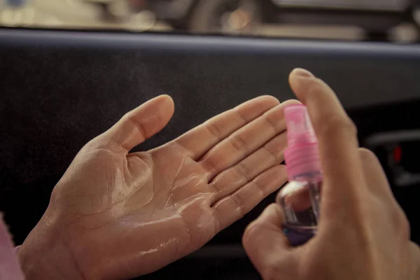 Hand disinfection with an alcohol-based disinfectant in a car. Hand disinfection after using the car during an epidemic.