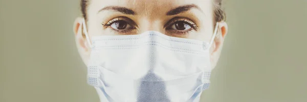 Coronavirus 'a karşı cerrahi koruyucu maske takan bir kadının panoramik fotoğrafı. Panorama tıbbi personel önleyici teçhizat. 