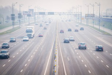 Kiev 'de duman, duman ve şiddetli hava kirliliği. Kiev, şehir caddesi, bir otoyolun yanındaki trafik manzarası. Kyiv, Ukrayna - 18 Nisan 2020
