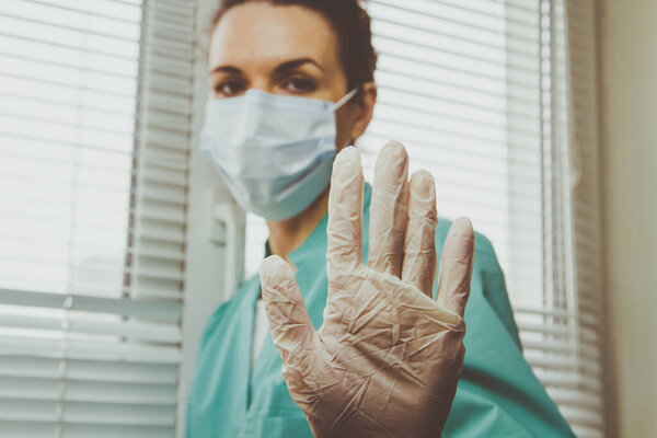  Врач медсестра в хирургической маске заставляет Жест остановить коронавирус. Конец эпидемии коронавируса
.