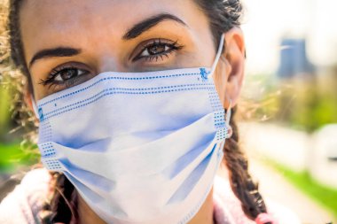 Coronavirus salgını: Koronavirüsü önlemek için koruyucu maske takan bir kadın. Sosyal uzaklık.