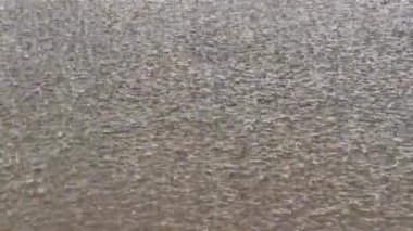 Pan shot damlaları ve yağmur akıntıları gölün yüzeyine dökülür. Suyun soğuk yüzeyinde yağmurdan daireler çiziyor. Göle sonbahar yağmuru. 4K. 